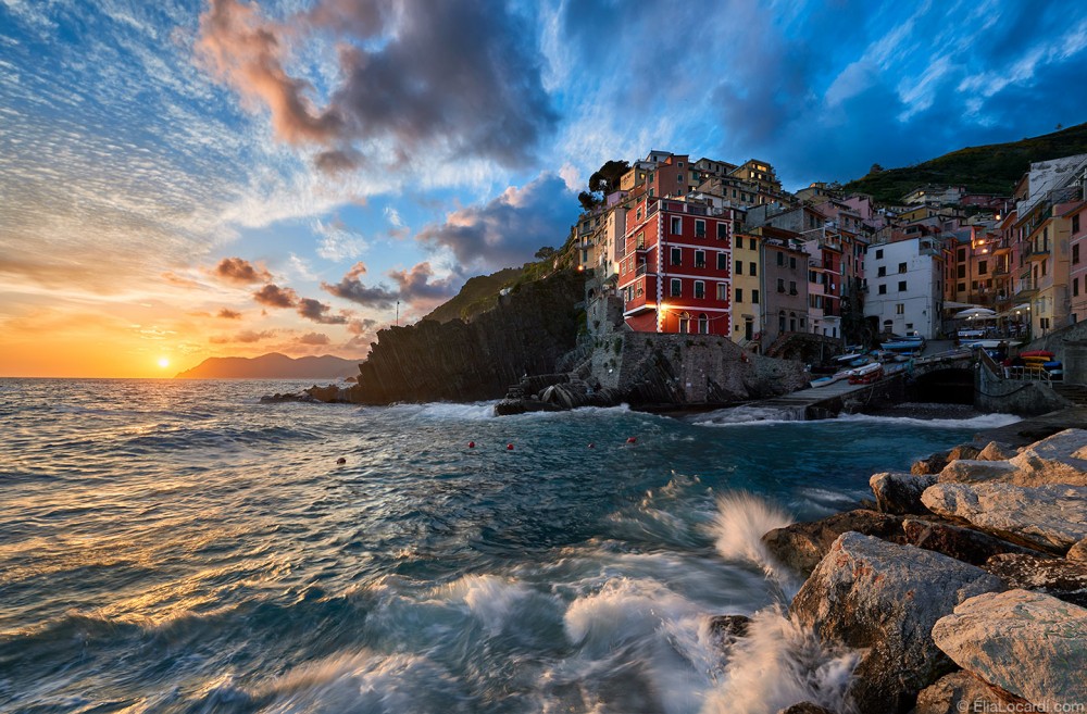 An unbelievable sunset in Riomaggiore as the waves crash on the rocky coastline.