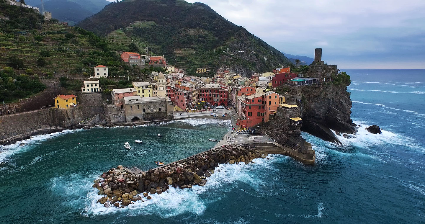 (Stormy seas as waves crash against the harbor of Vernazza in Le Cinque Terre, Italy.)